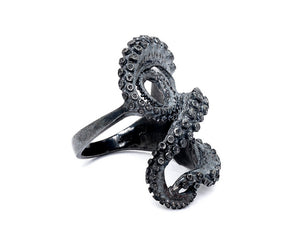 side view of tentacle sculpture ring 2, which has 3 tentacles that coil across the wearer's finger, a thick band.