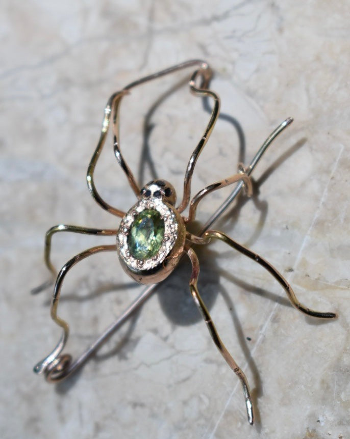 14k rose gold spider pin/pendant with 6 black diamond eyes and green/blue/gold color-change sapphire