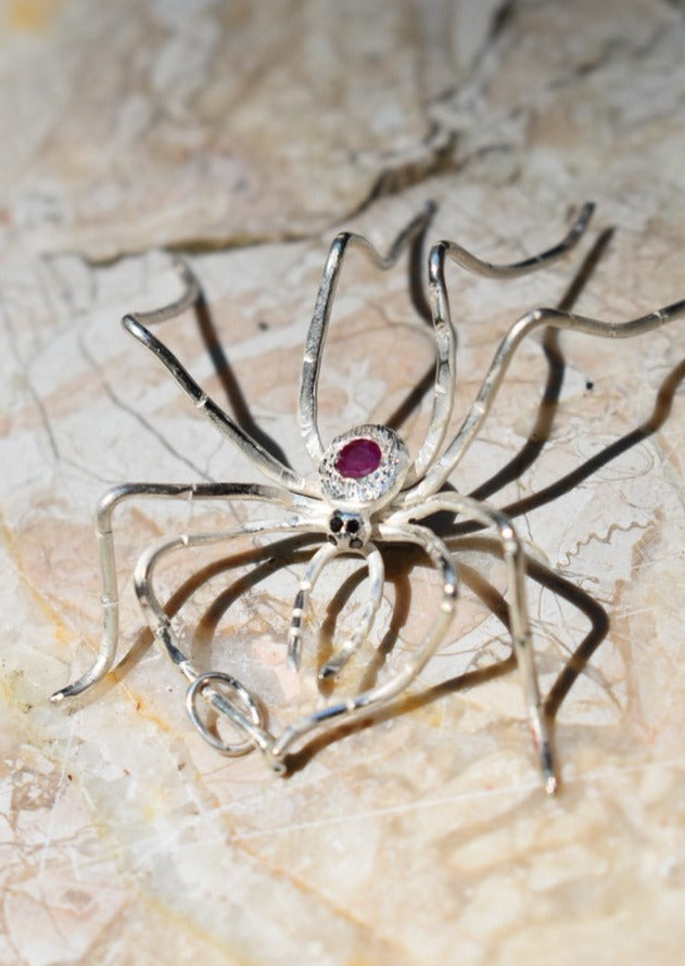 Silver spider pendant with ruby, hand engraved body and black diamond eyes