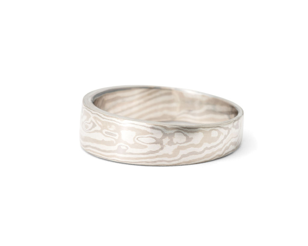 mokume gane ring in 14k and 18k palladium white gold and silver, heavy, tapered band with a combination wood-grain and fish-eye pattern, ring size 9.
