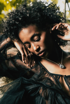 Silver anatomical heart locket and 14k rose gold honeycomb dome ring modelled by Maryam Jama, photo by Kirsten Miccoli