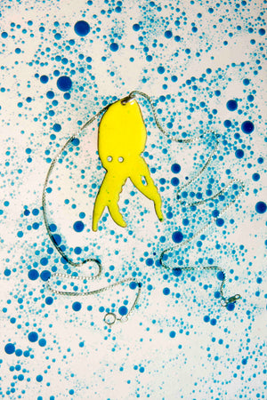 glass enamelled squid silhouette, profile of squid with cutout eyes, bright lime green vitreous glass enamel, fired to a high gloss finish, by peggy skemp 2008, sold at Wolfbait and B Girls, Chicago, IL. Photo with blue bubbles by AJ Kane.