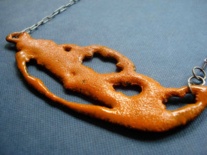 Orange sugar fired vitreous enamel on copper, glass enamel phasmid necklace by Peggy Skemp 2008 from the Sensitive Parasite collection.