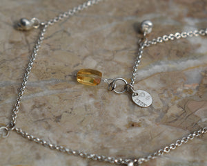 detail shot of the silver multi shell necklace on 1.65mm rolo chain with a silver tag baring the makers marks  PS 925 and a dangling faceted natural citrine baguette gem. By Peggy Skemp 2021.